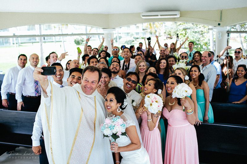 Moon Palace Cancun wedding - catholic father doing a selfie with church guests - Ivan Luckie Photography